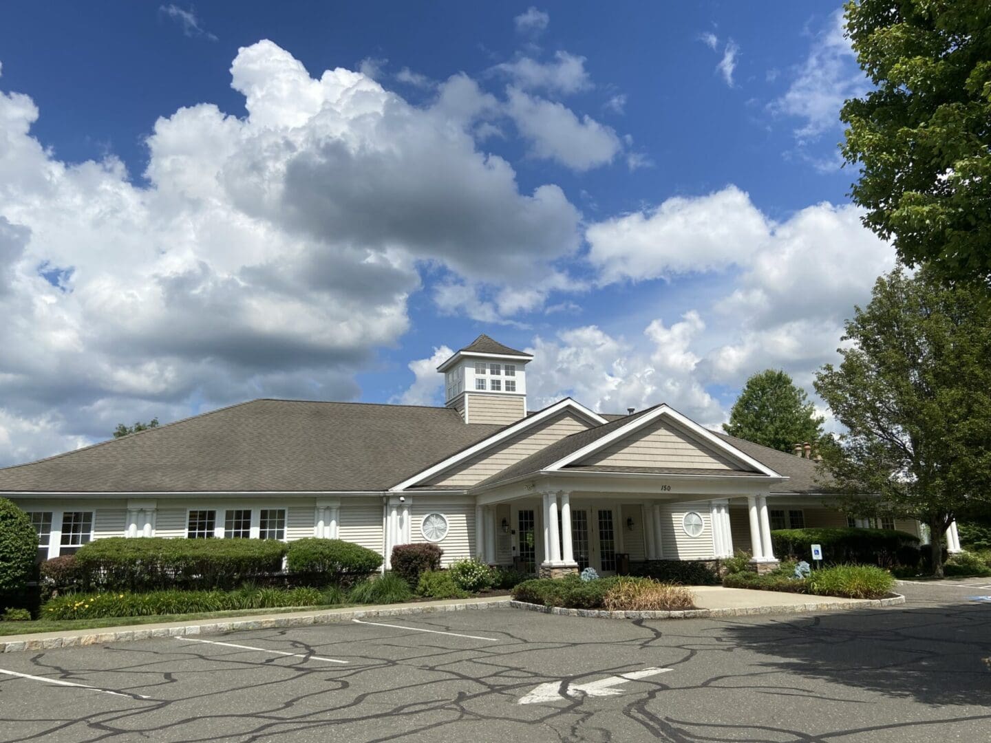 A large white building with a clock tower in the center.