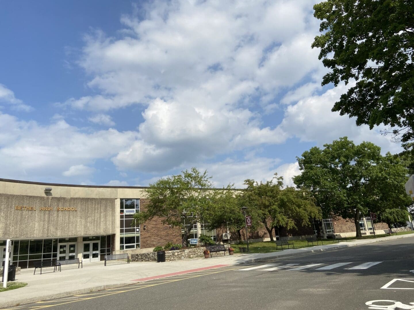 A building with trees and clouds in the background.