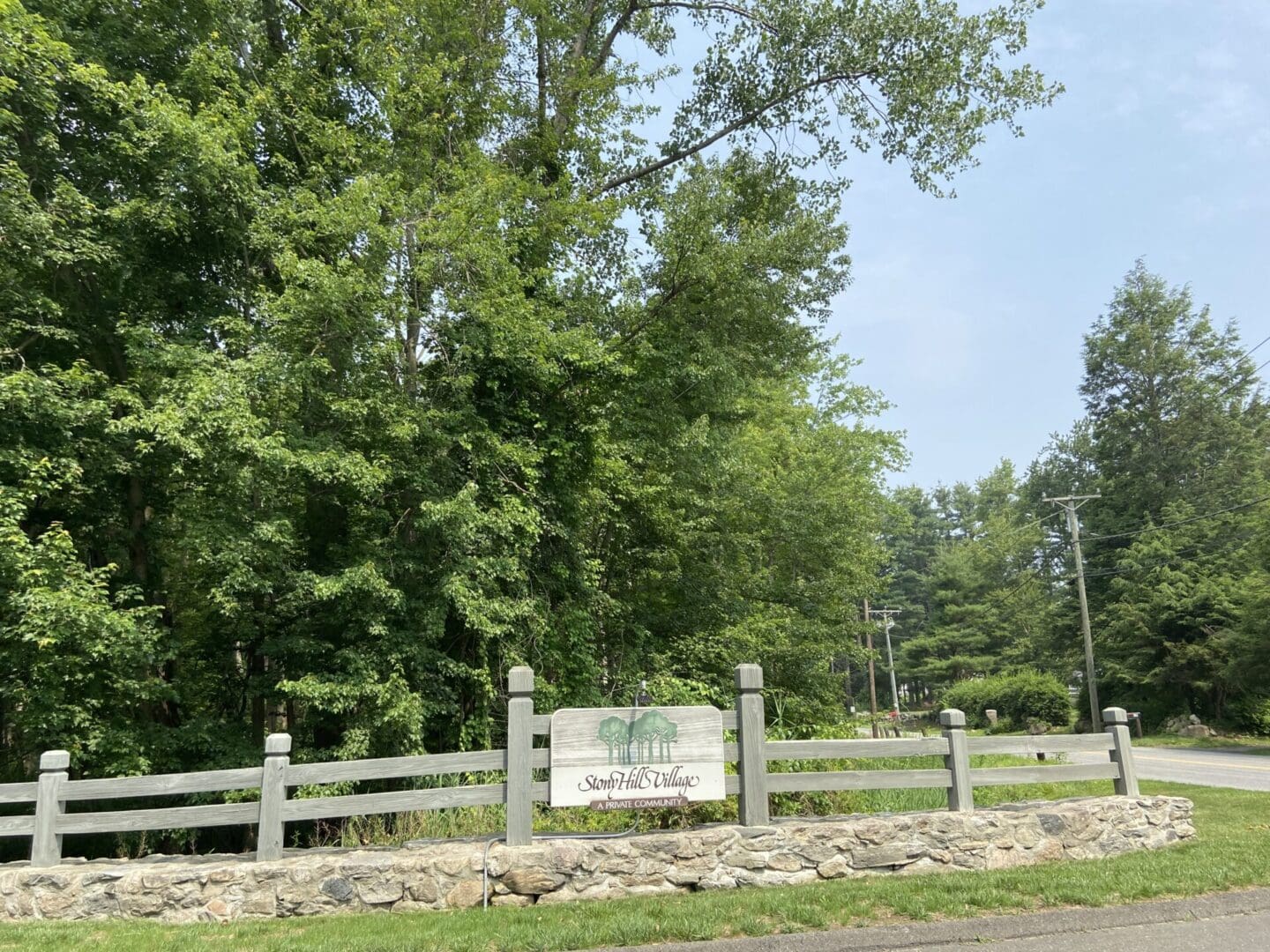 A sign on the side of a road near some trees.