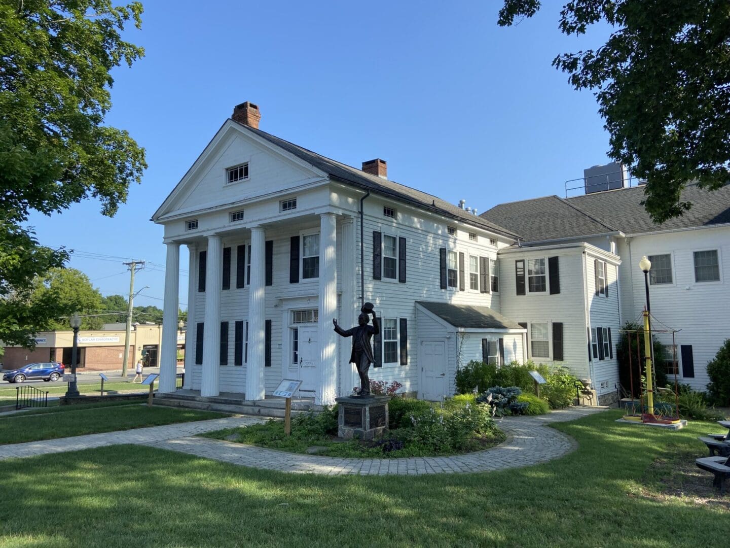 A white house with a statue of a person in the middle.