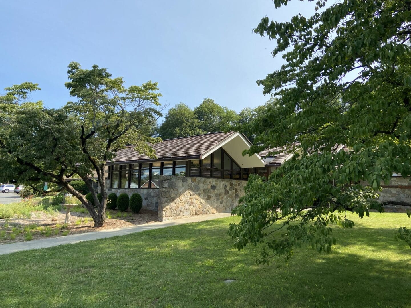 A stone building in the middle of a grassy field.