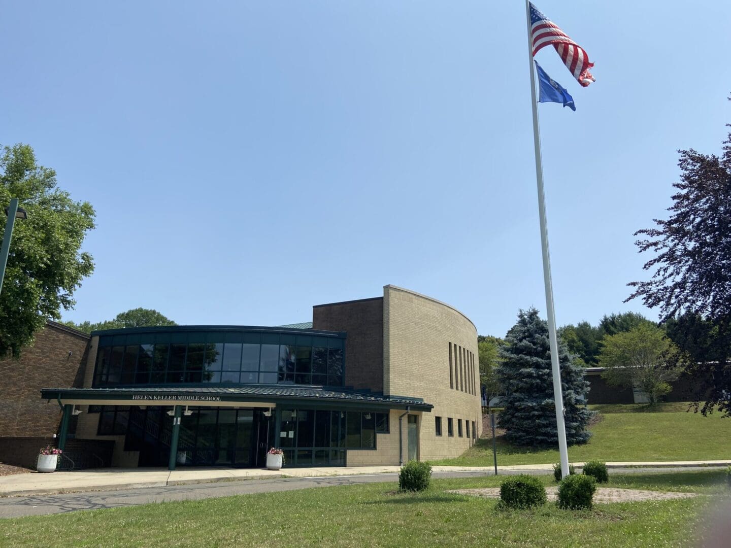 A large building with trees and bushes in front of it.