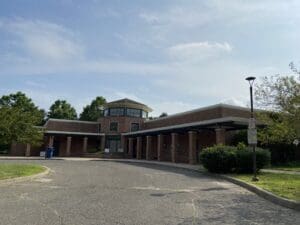 A large brick building with trees in the background.