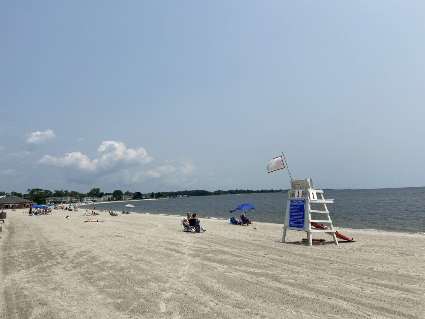 A beach with lifeguards and people on the sand.