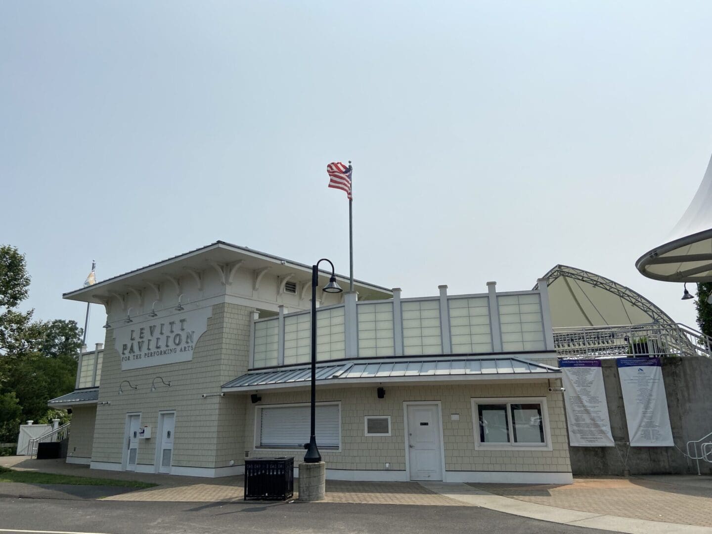 A white building with a flag in front of it.