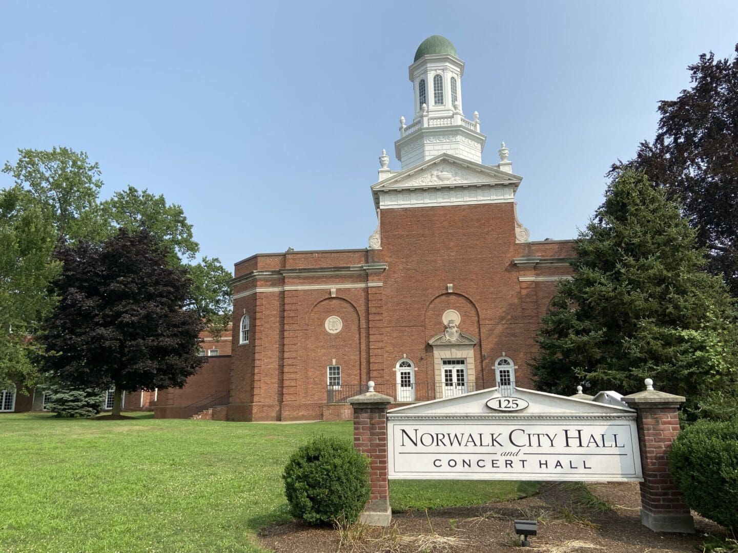 A brick building with a sign that says norwalk city hall.