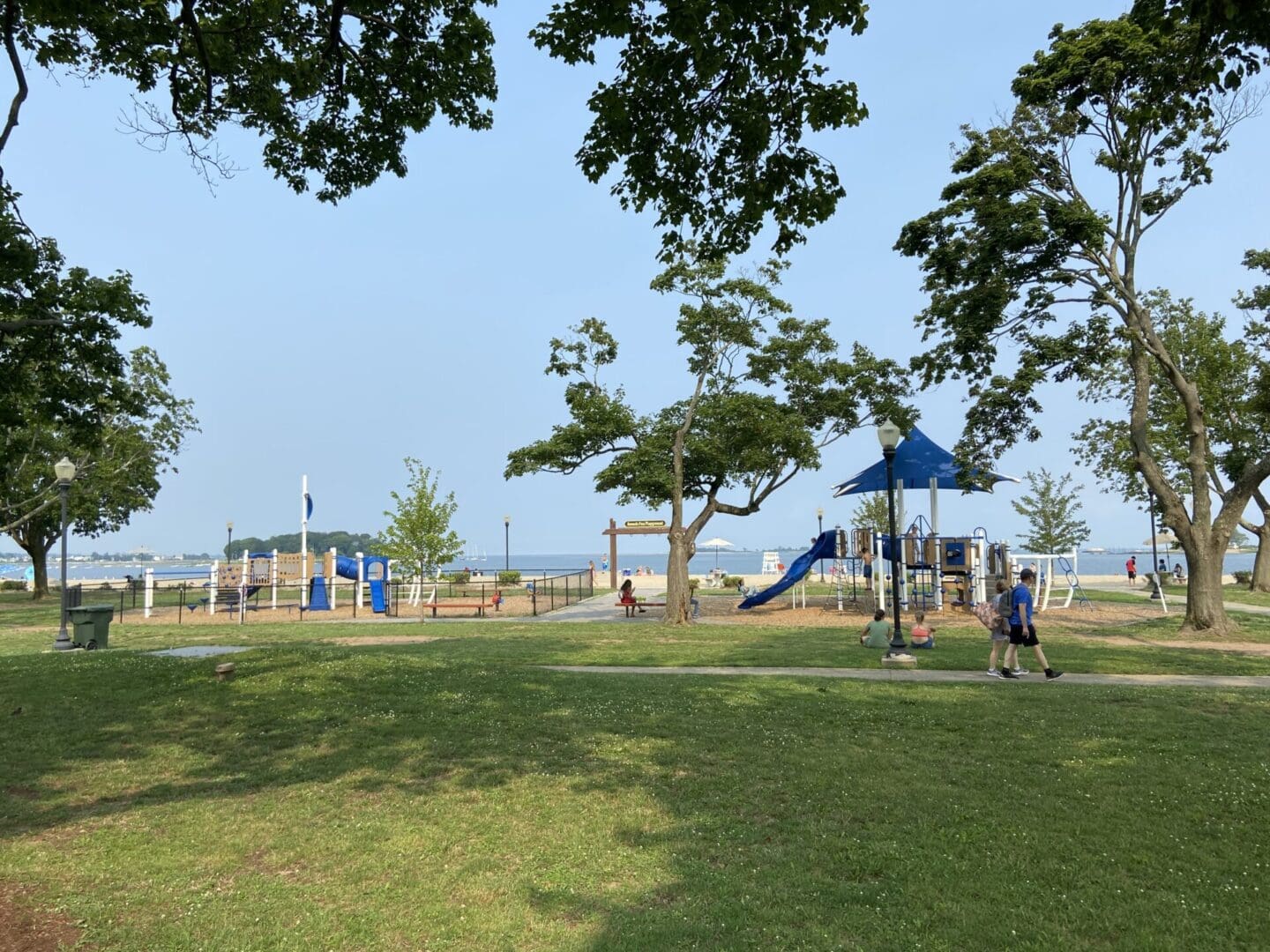 A park with a playground and a view of the water.