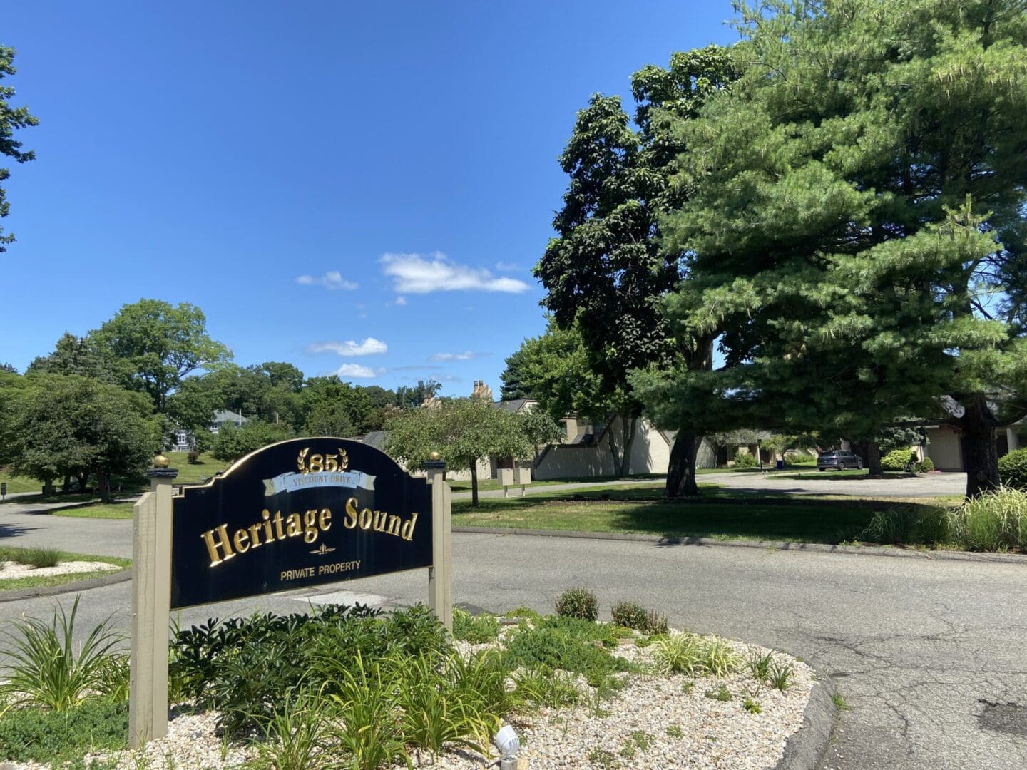 A sign in front of a tree with a sky background