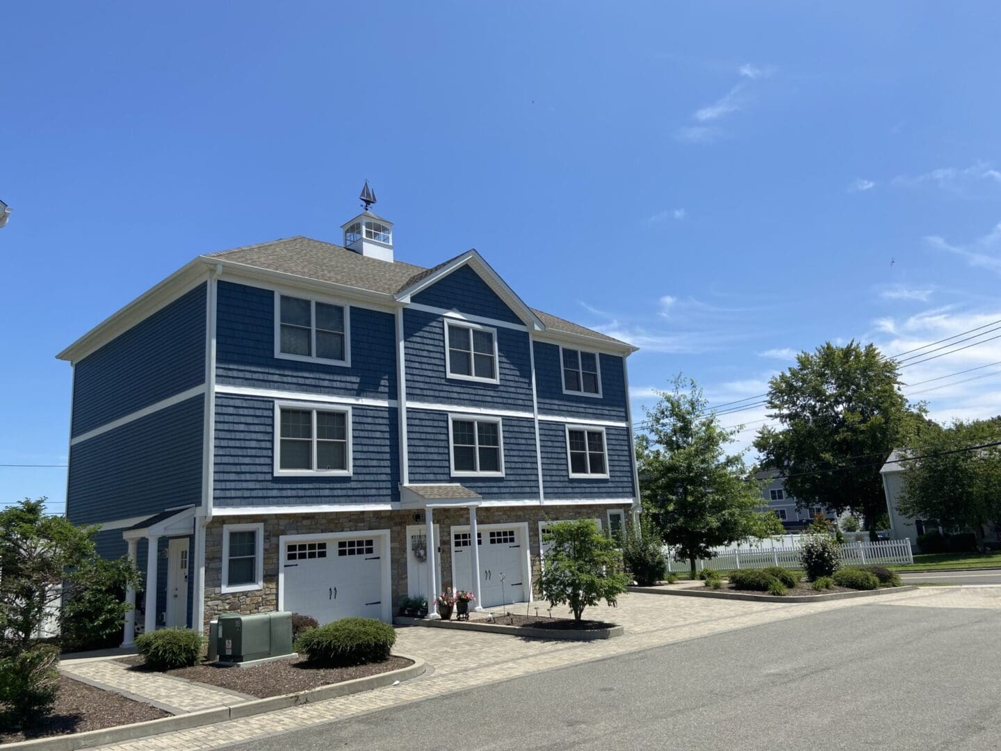 A blue house with two garage doors on the street.