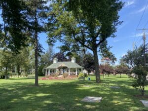 A park with trees and a gazebo in the middle of it.