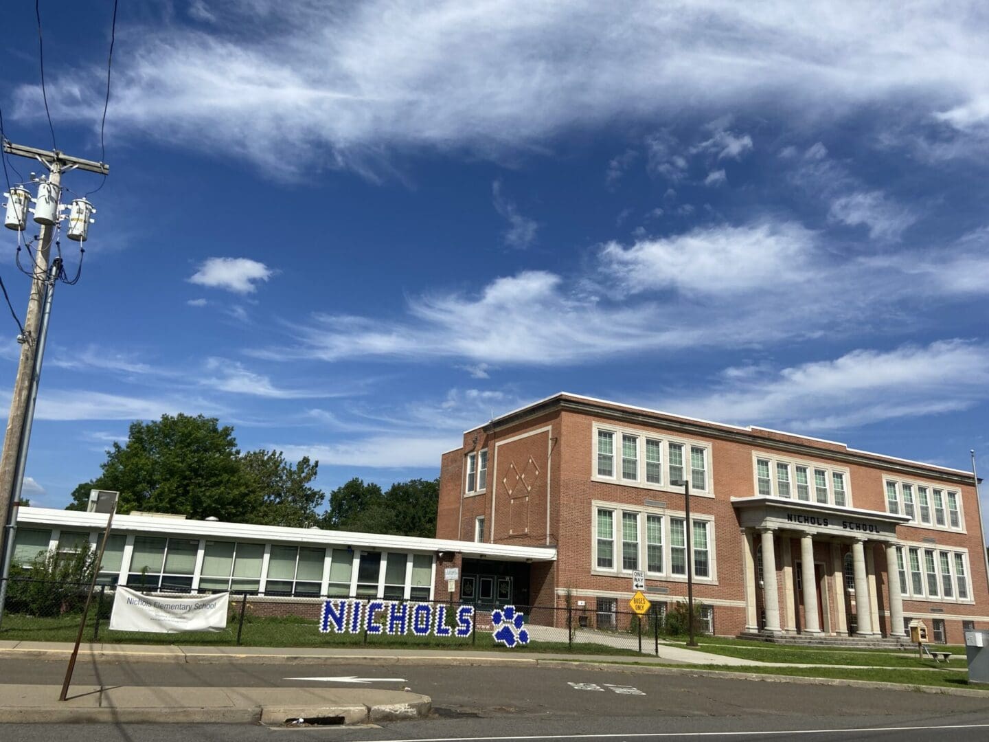 A school building with a sign on it.