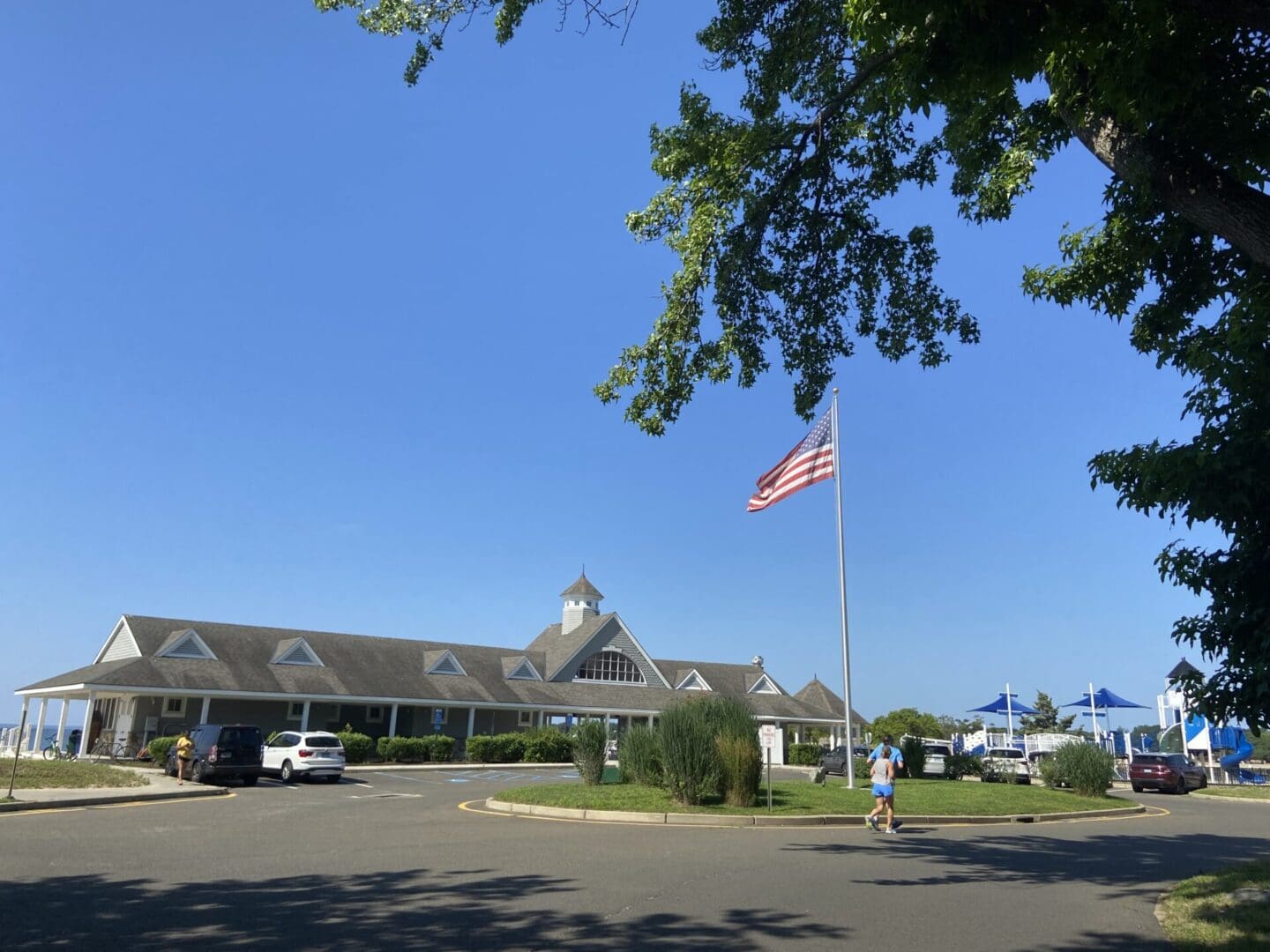 A large building with an american flag flying in the background.