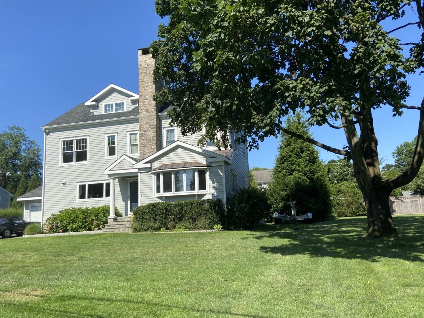 A large white house sitting on top of a green field.