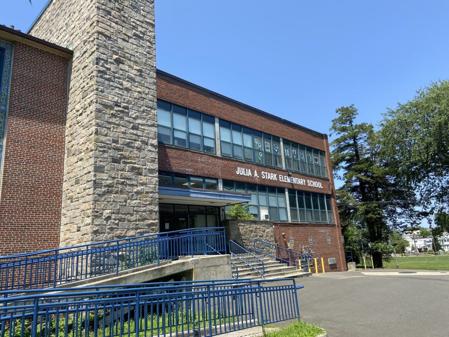 The entrance to a school building with blue railings.