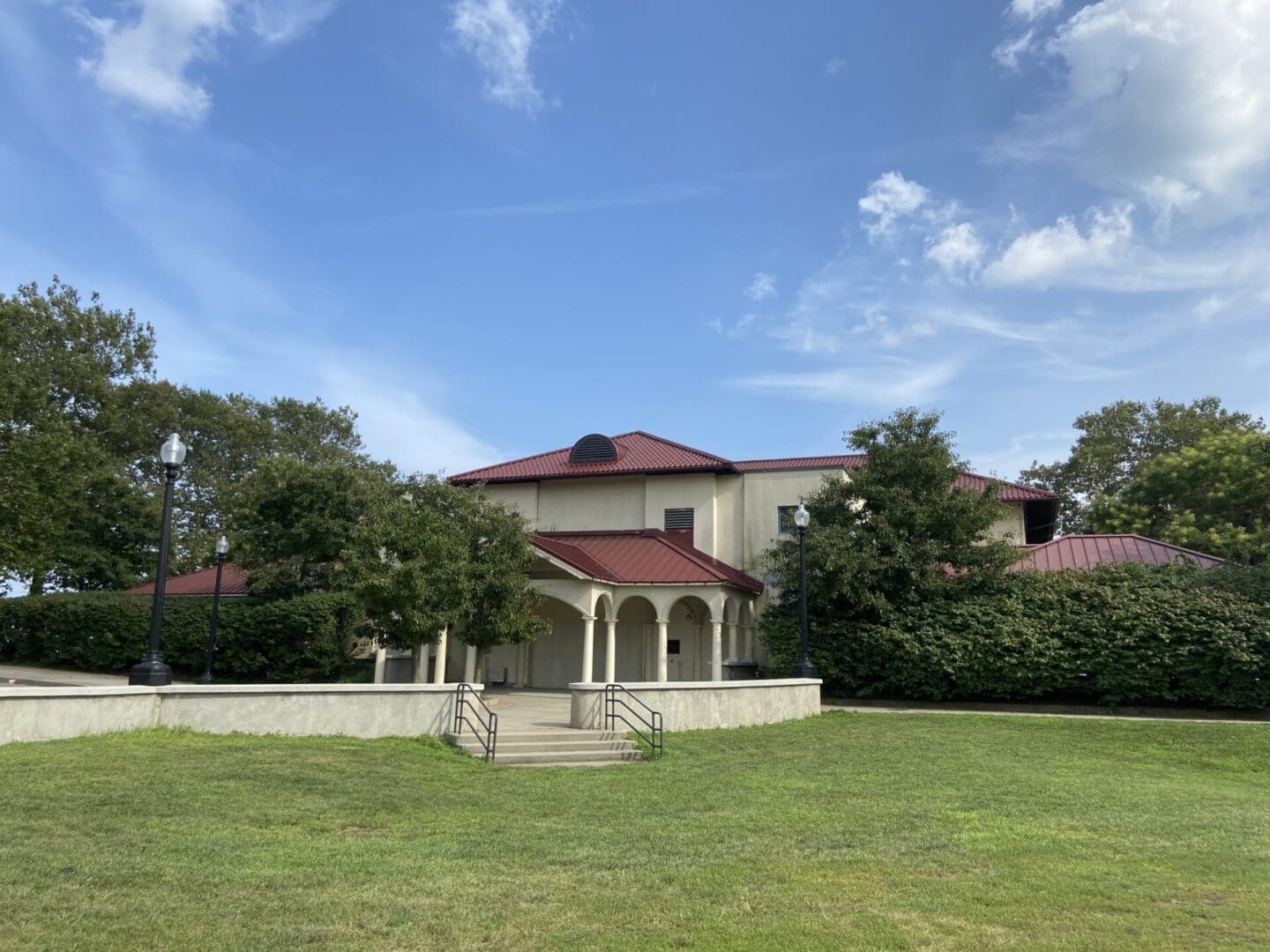 A large white house with a red roof and a gazebo.