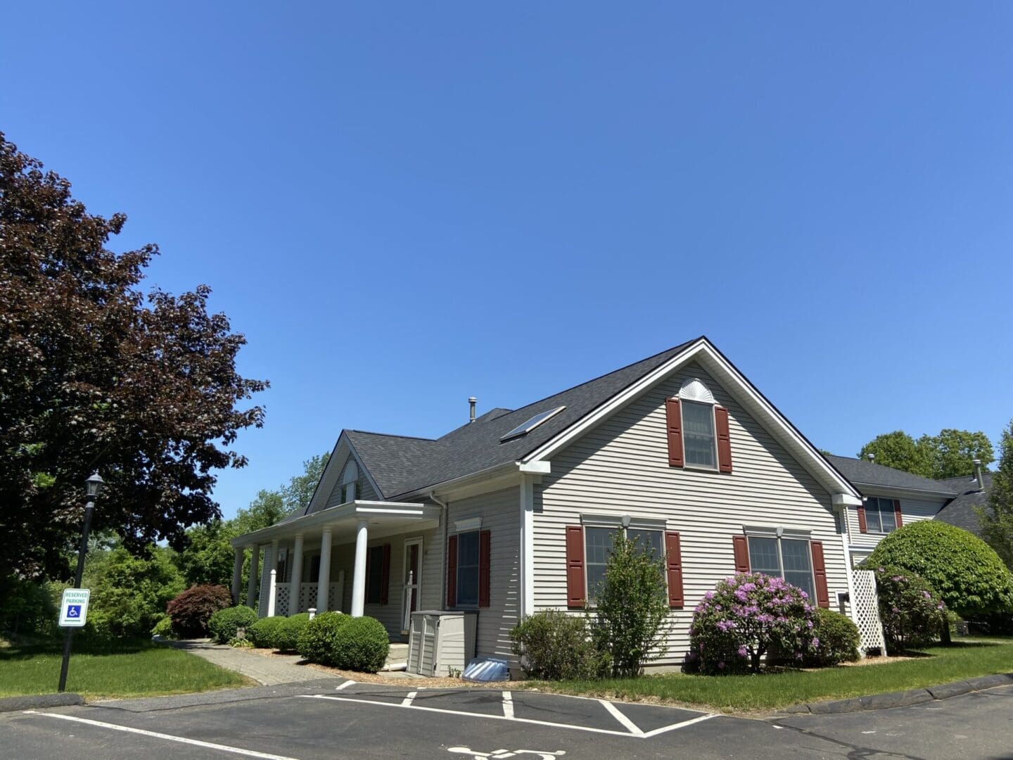 Gray house with red shutters and a porch.