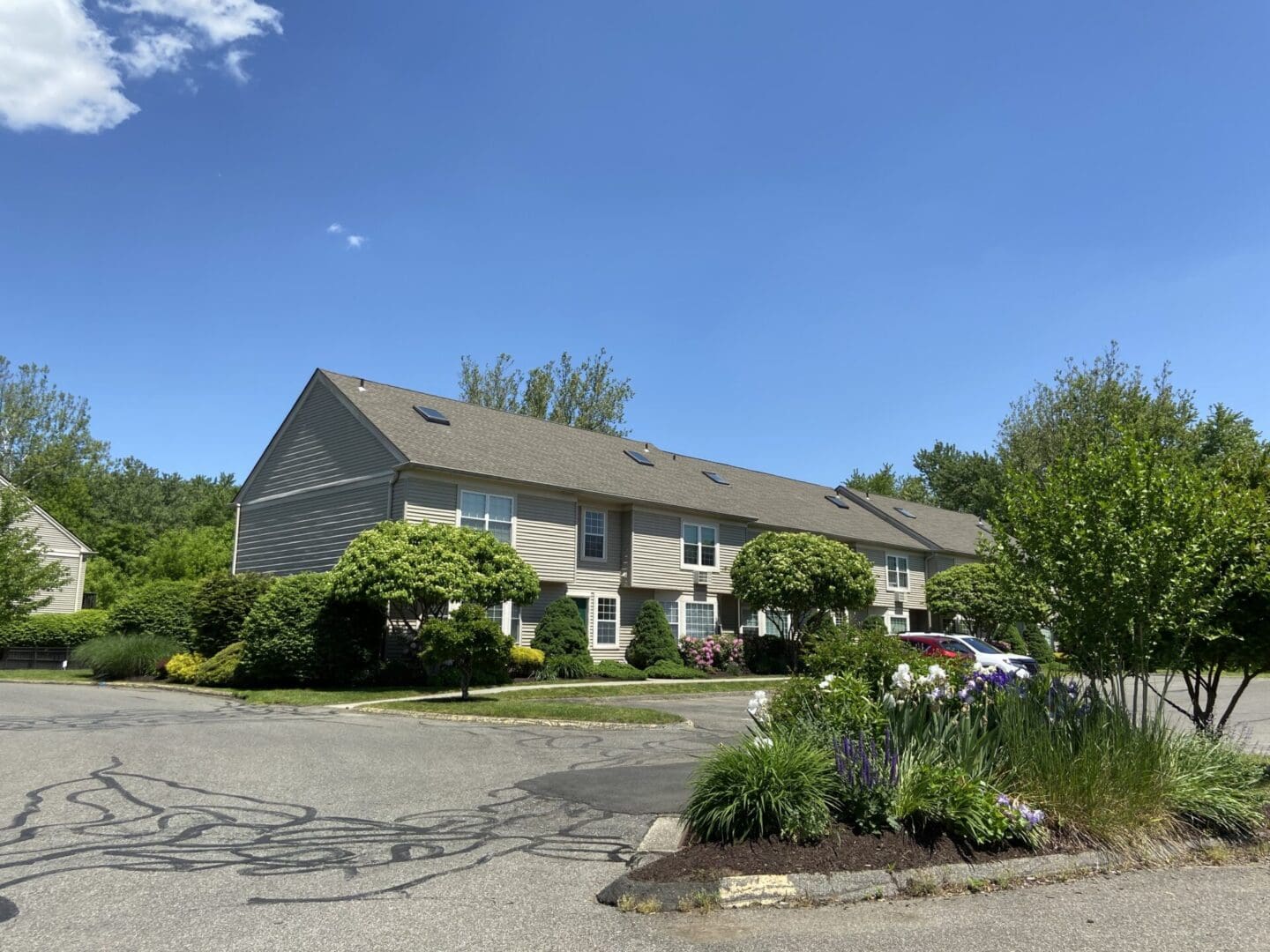 Tan townhouses, sunny day, landscaped grounds.