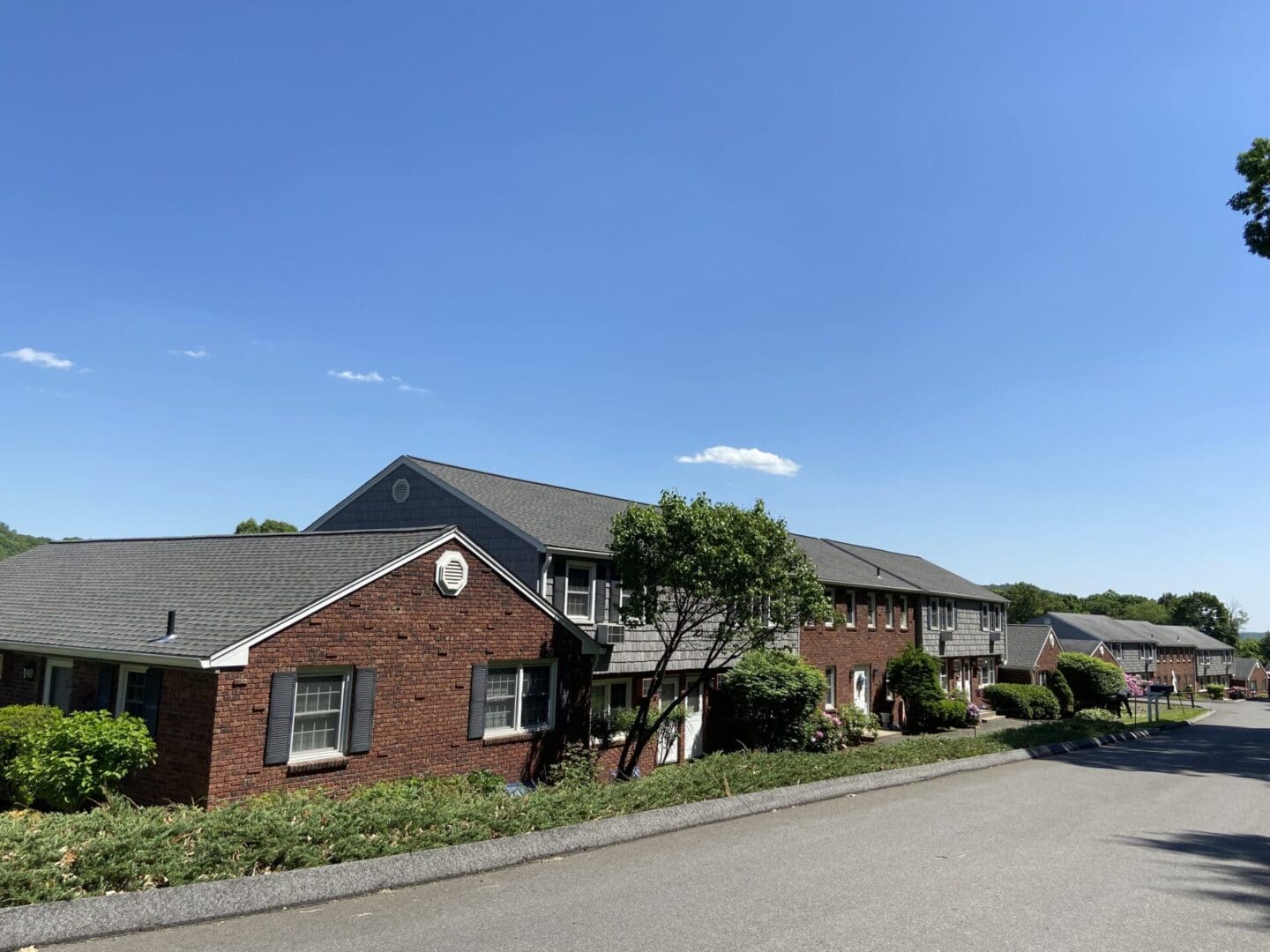 Row of brick townhouses on a sunny day.