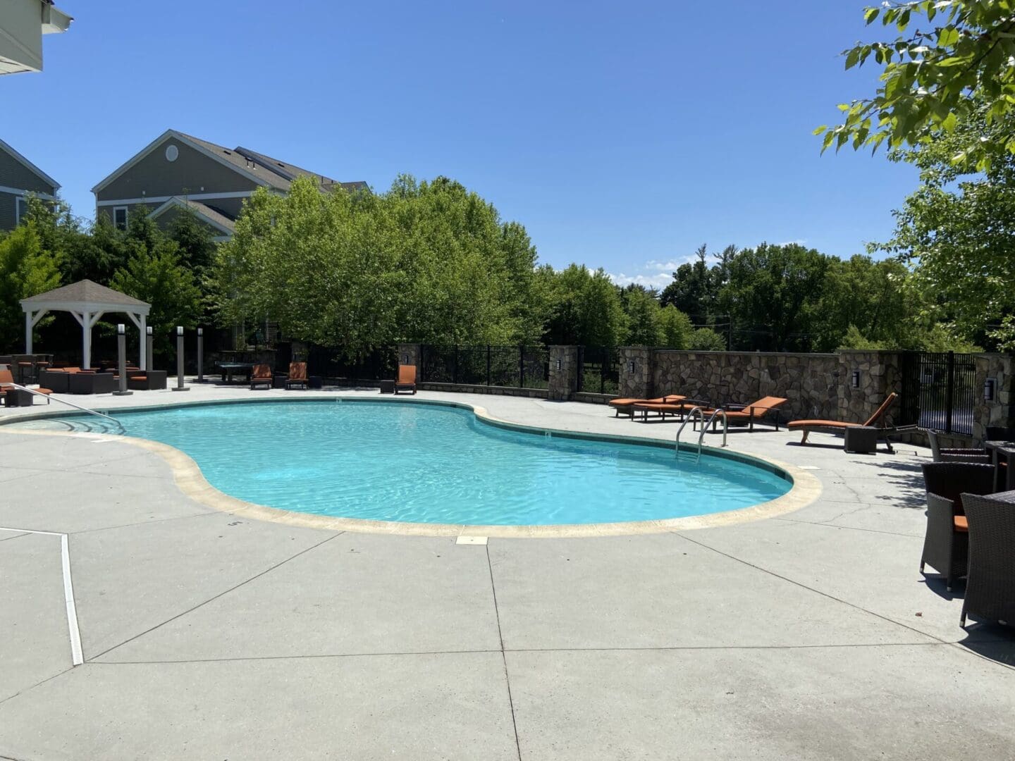 Swimming pool with lounge chairs and a pergola.