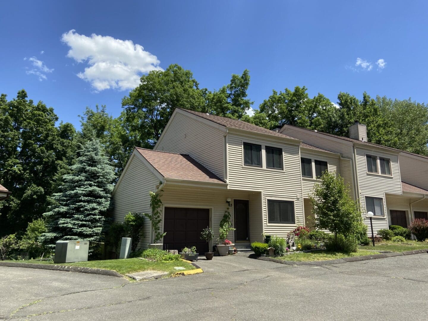 Beige townhouse with brown garage door.