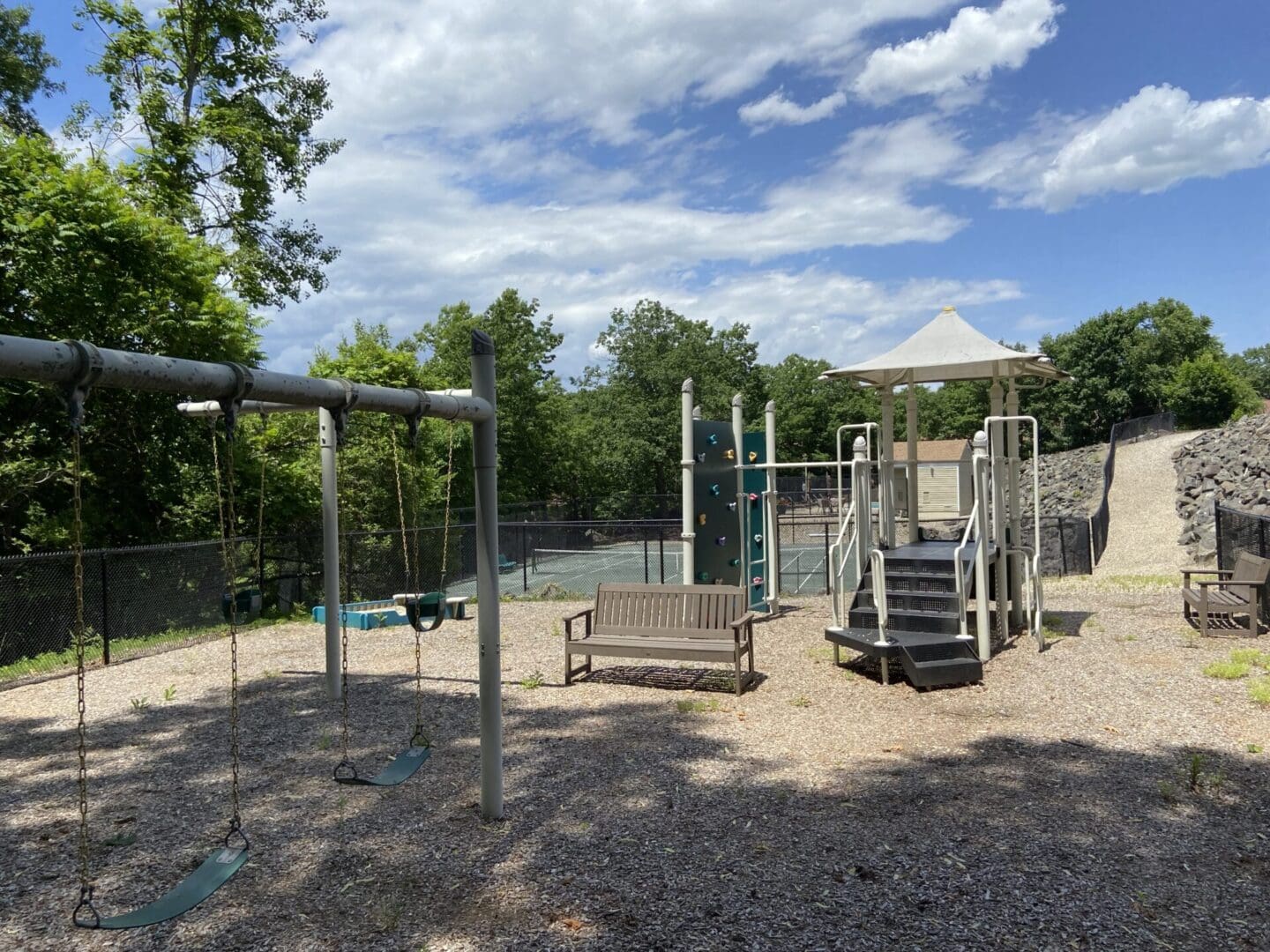 Empty playground with swings and climbing frame.