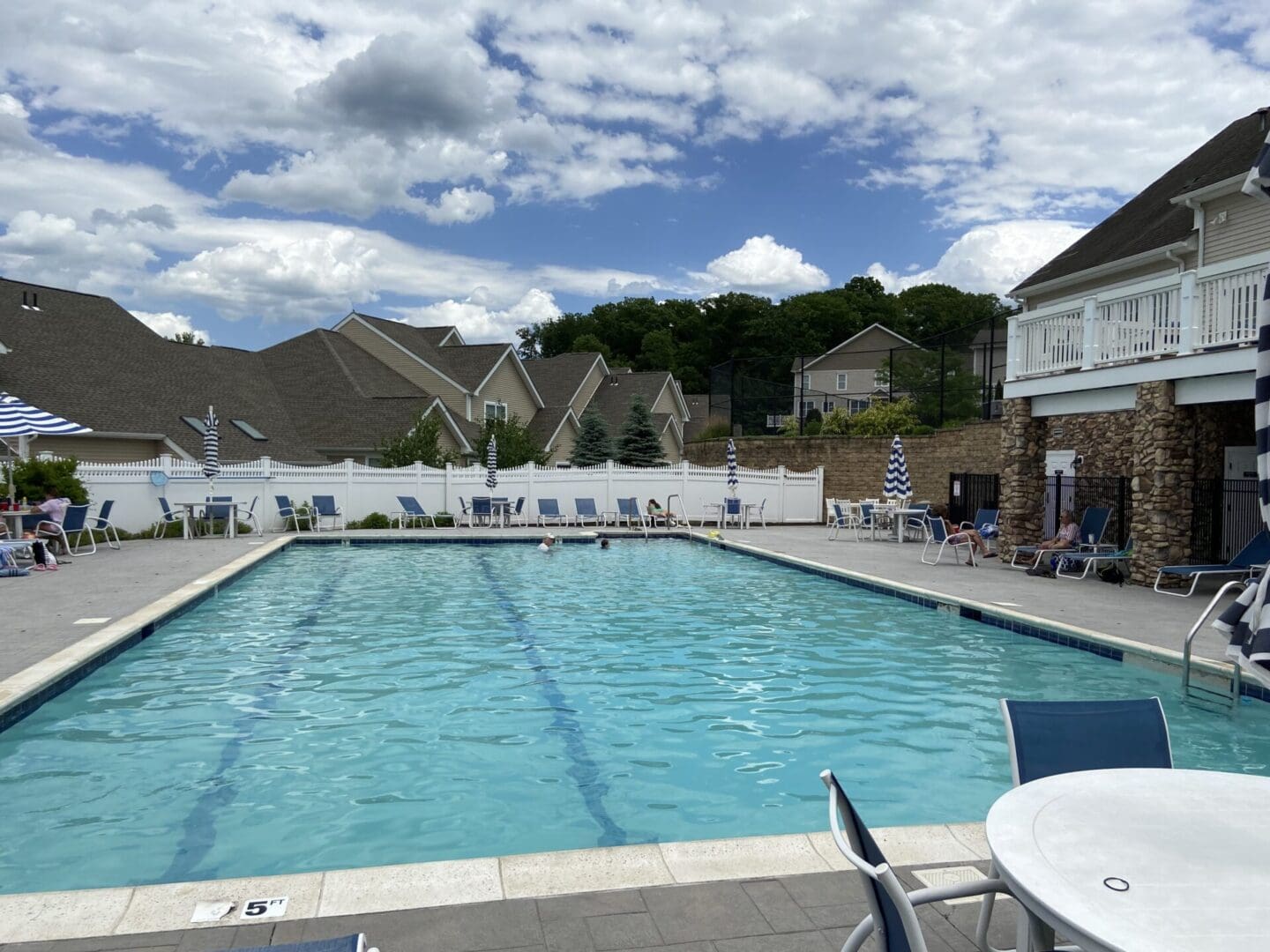 Blue pool with lounge chairs and umbrellas.