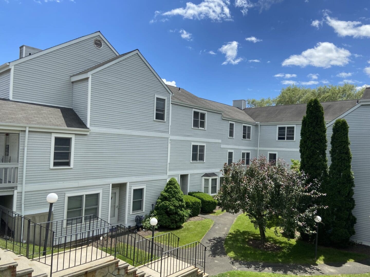 Gray apartment building, landscaped courtyard.