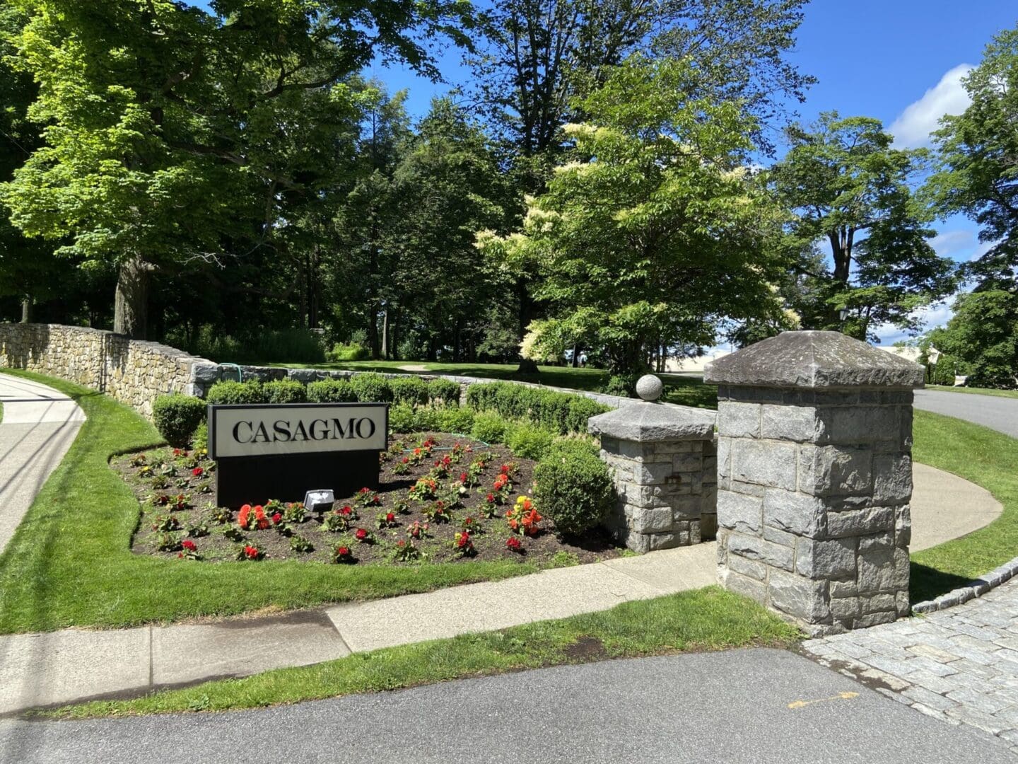 Stone pillars with Casagmo sign and flowers.