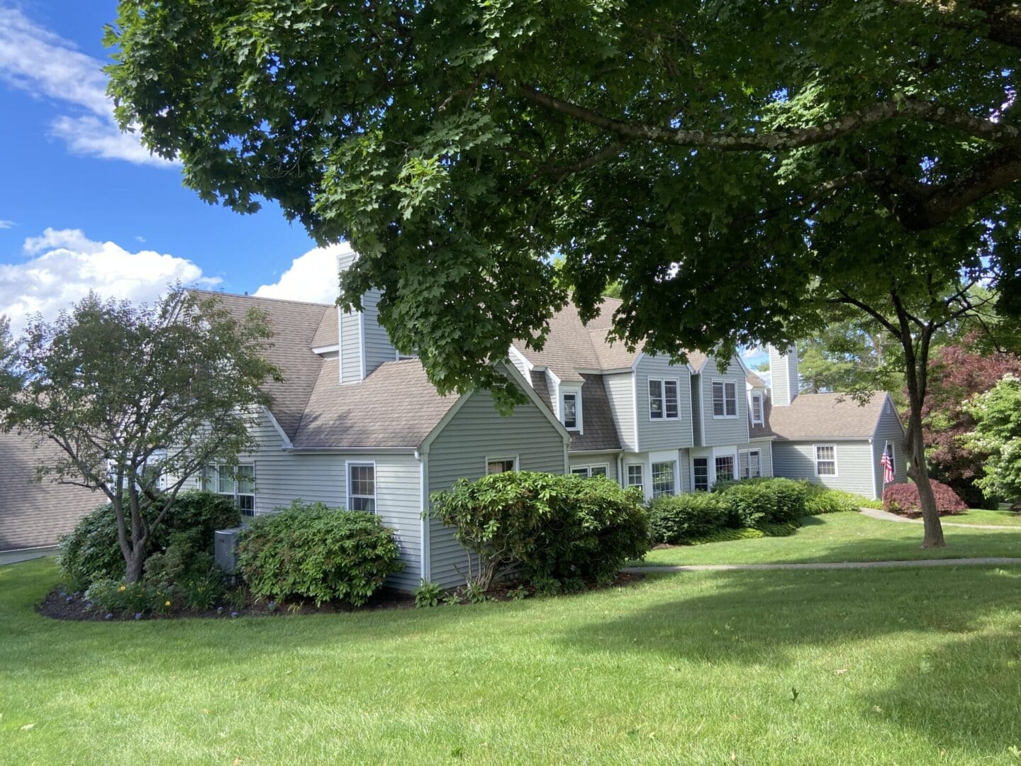 Gray house, green lawn, sunny day.