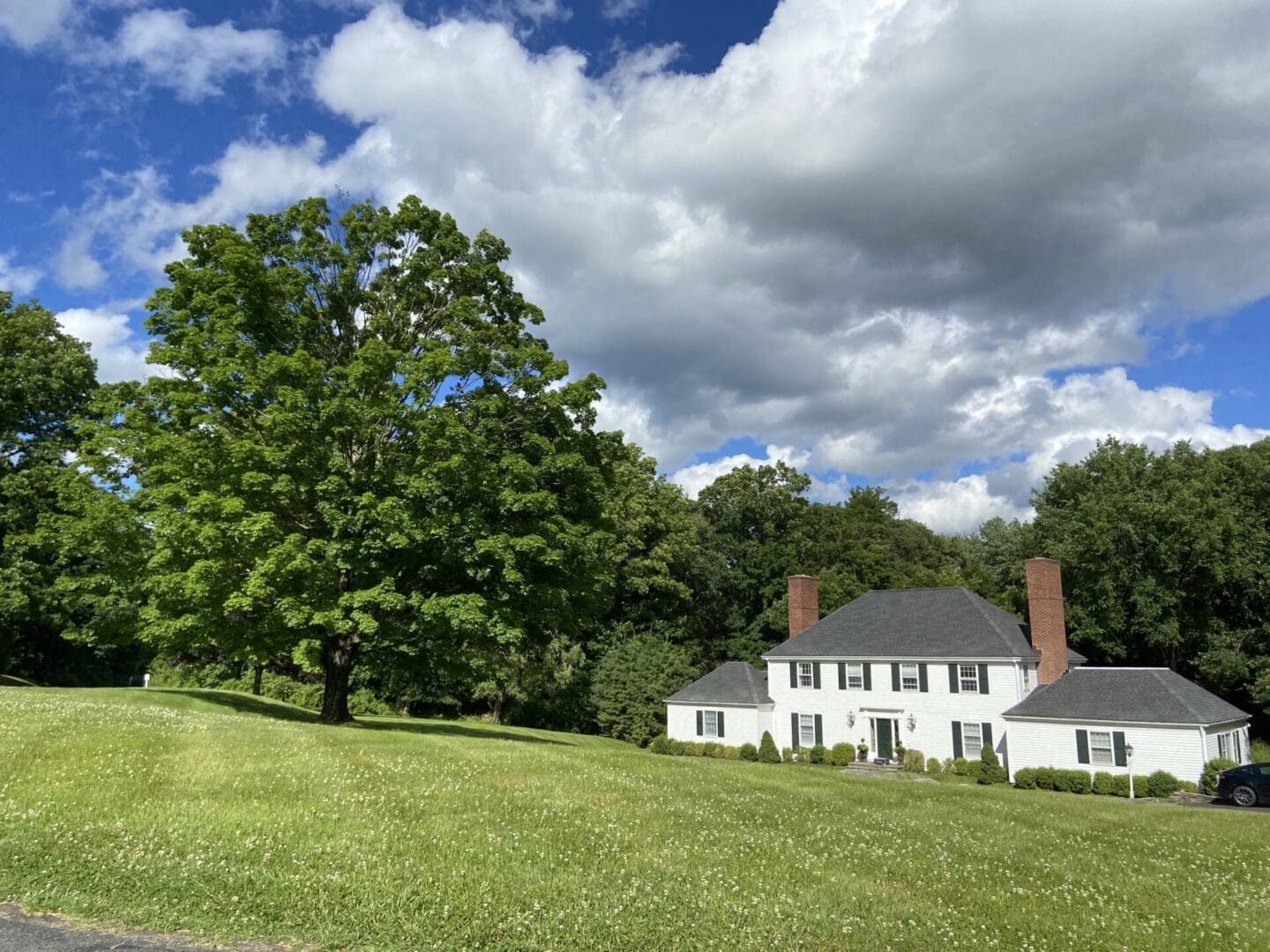 White house with green lawn and trees.