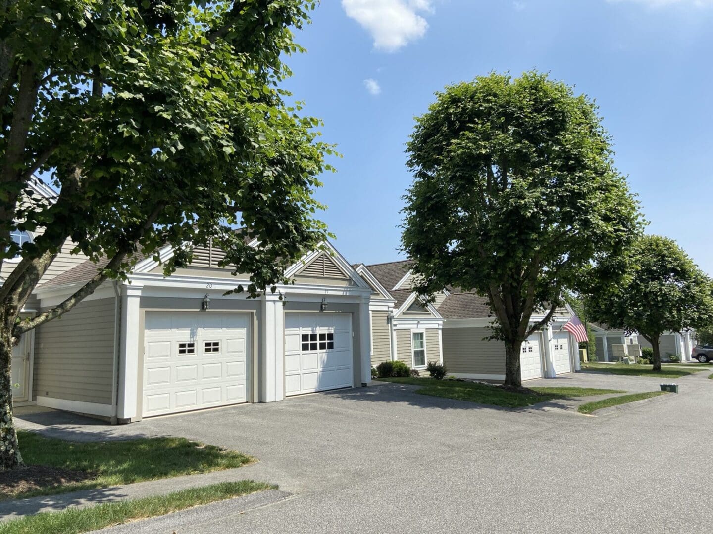 Tan houses with attached garages and trees.