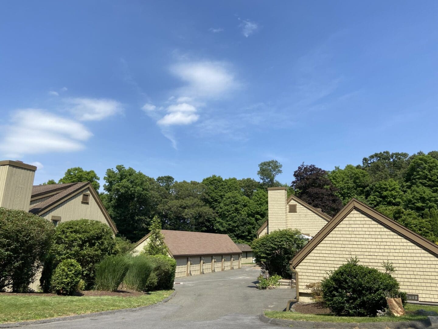 Tan houses and garages under blue sky.