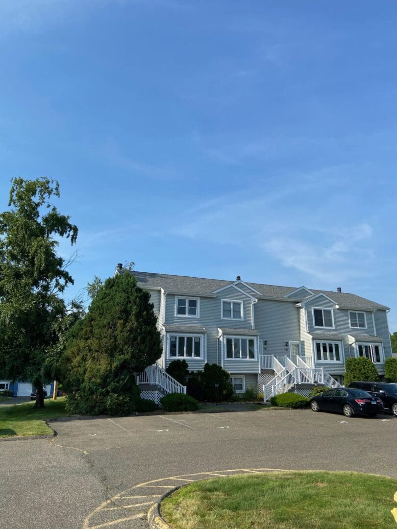 Gray townhouses with cars parked outside.