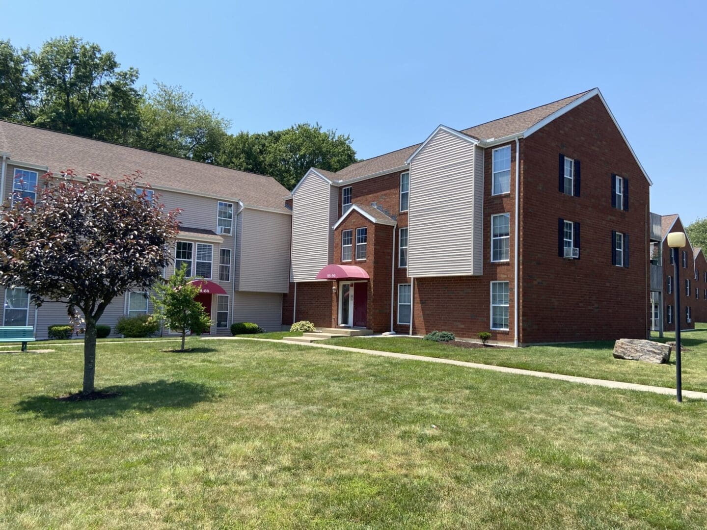 Brick apartment building with a lawn.