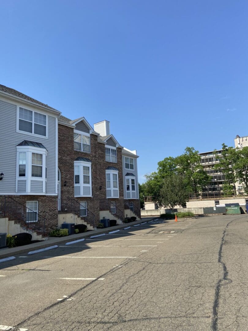 Townhouse with parking lot and blue sky.