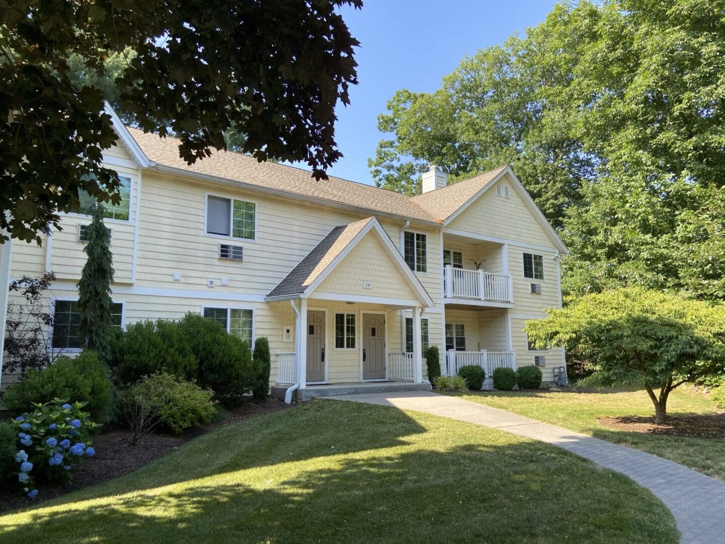 Yellow house with two entrances and a walkway.