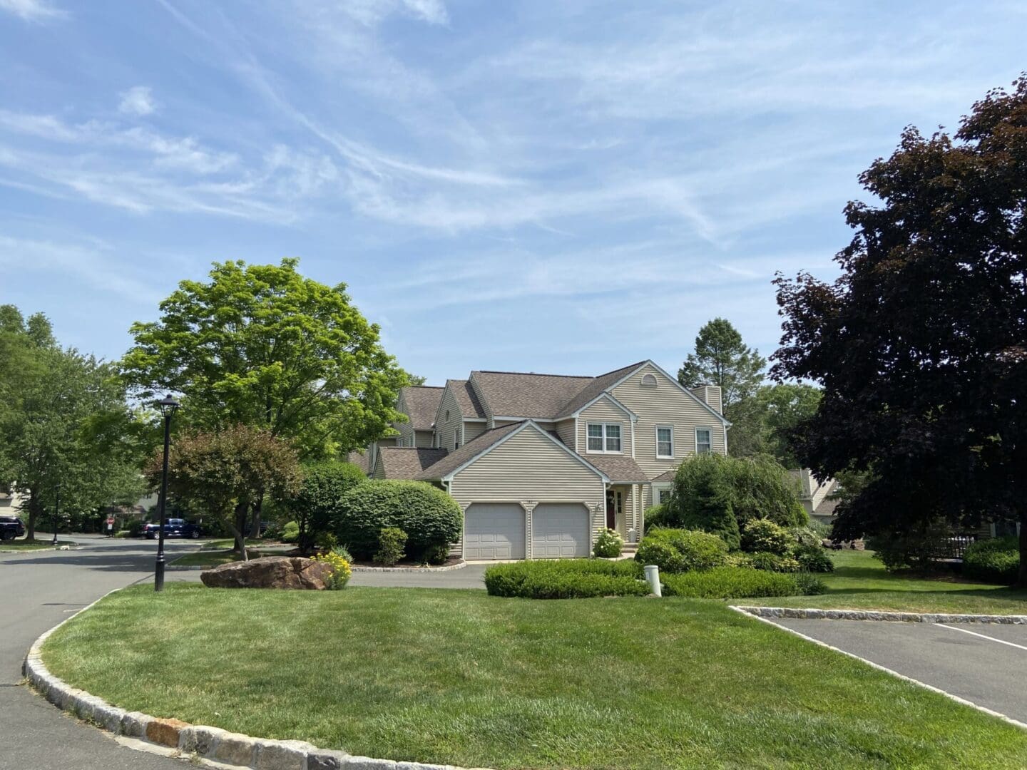 Beige house, green lawn, sunny day.