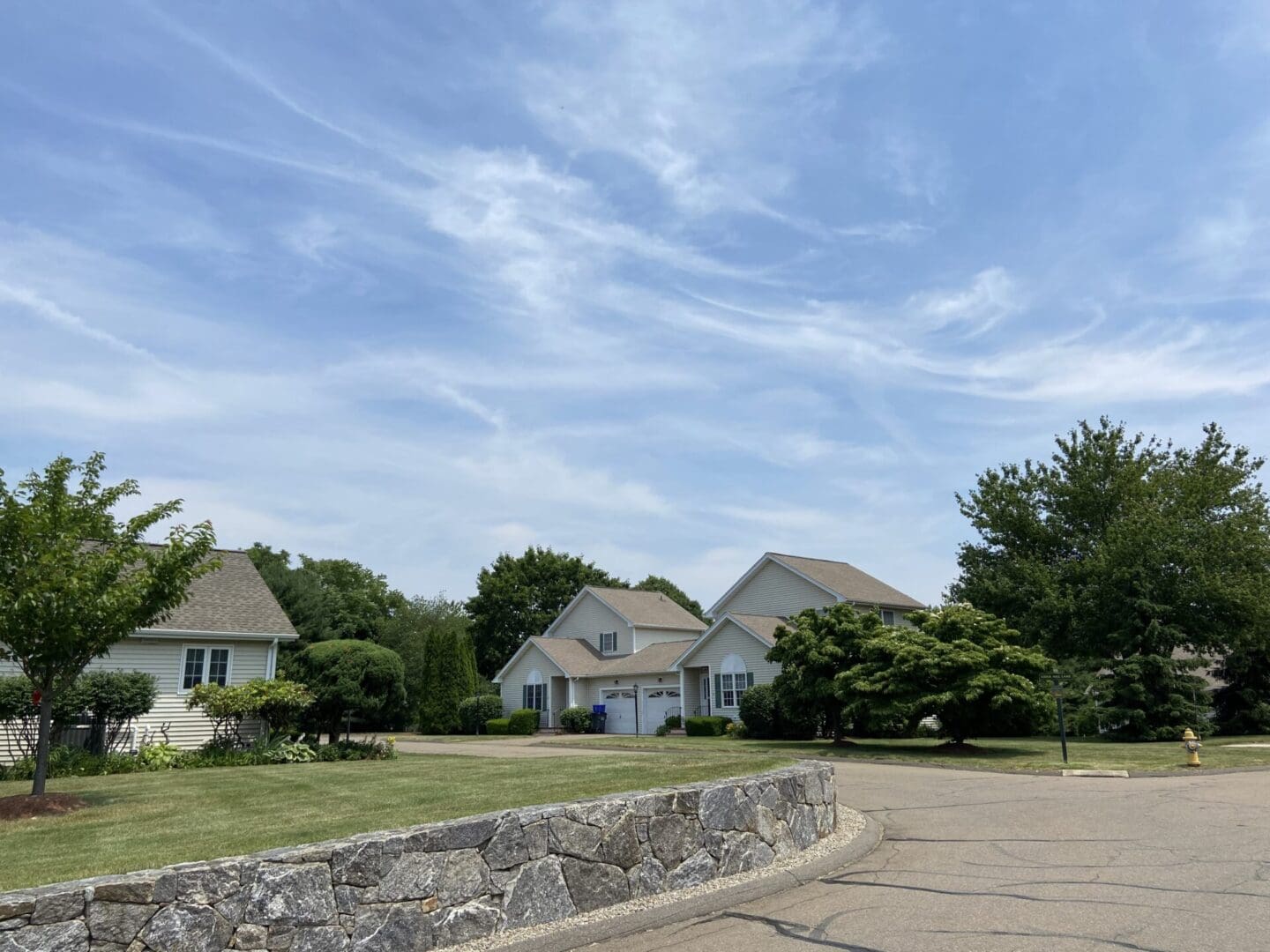 Suburban homes with blue sky and clouds.