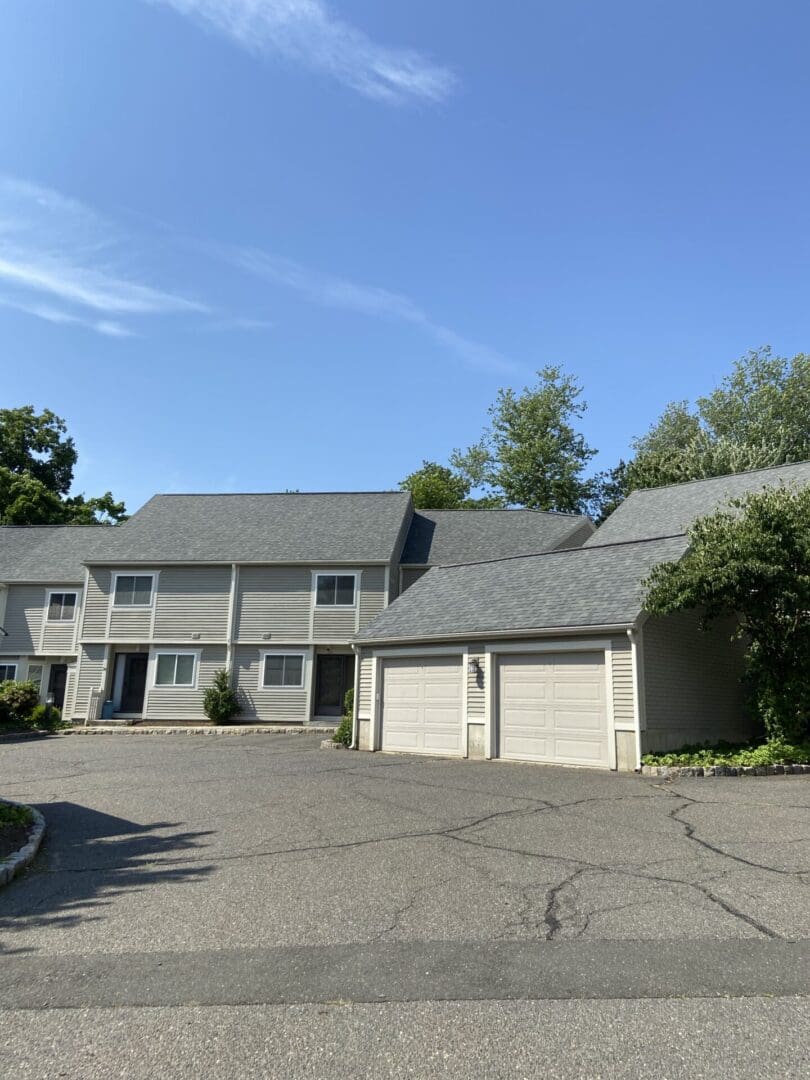 Tan townhouse with double garage doors.