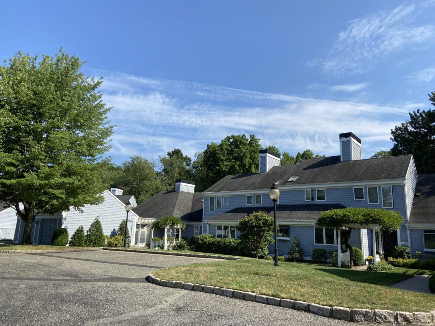 Blue houses with a paved driveway.