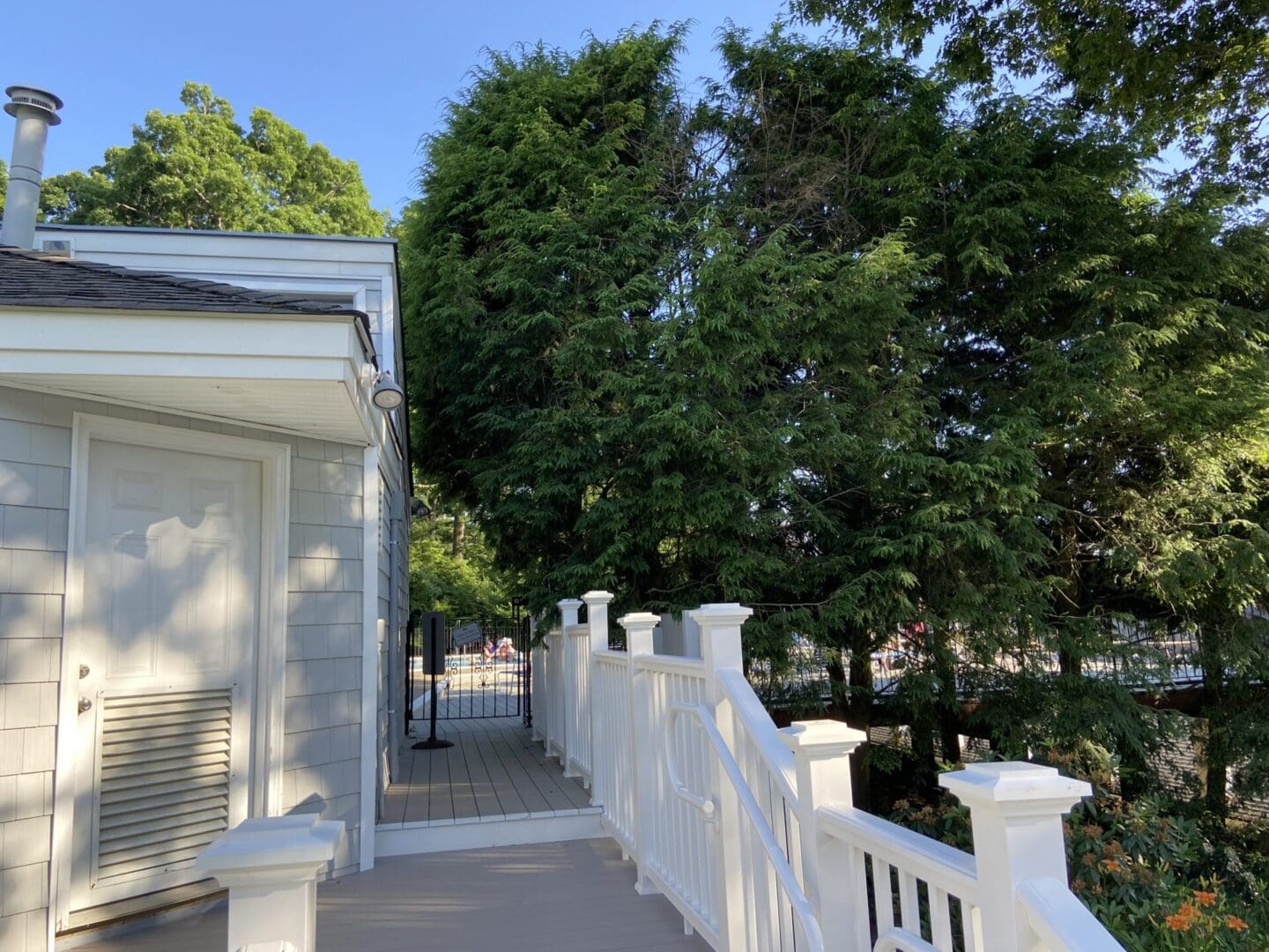 White deck with railing near a house.