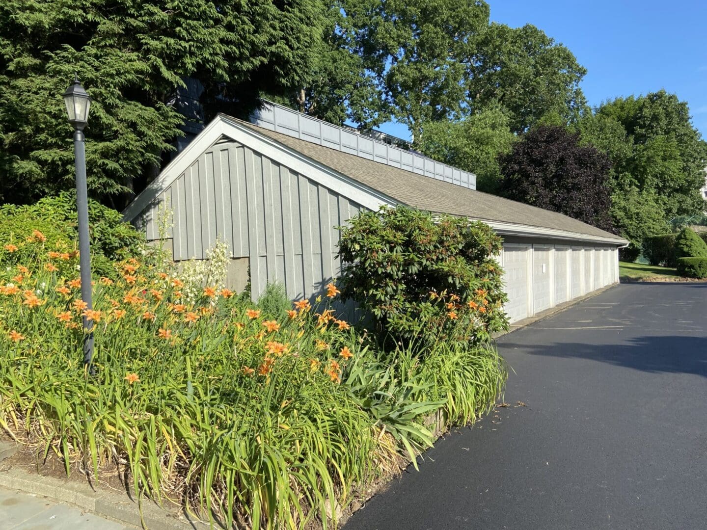 Multi-car garage with flowering plants.