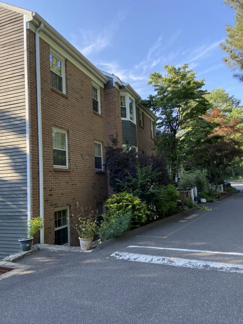 Brick building with a driveway and trees.