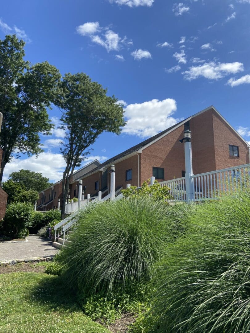 Brick building with green grass and blue sky.