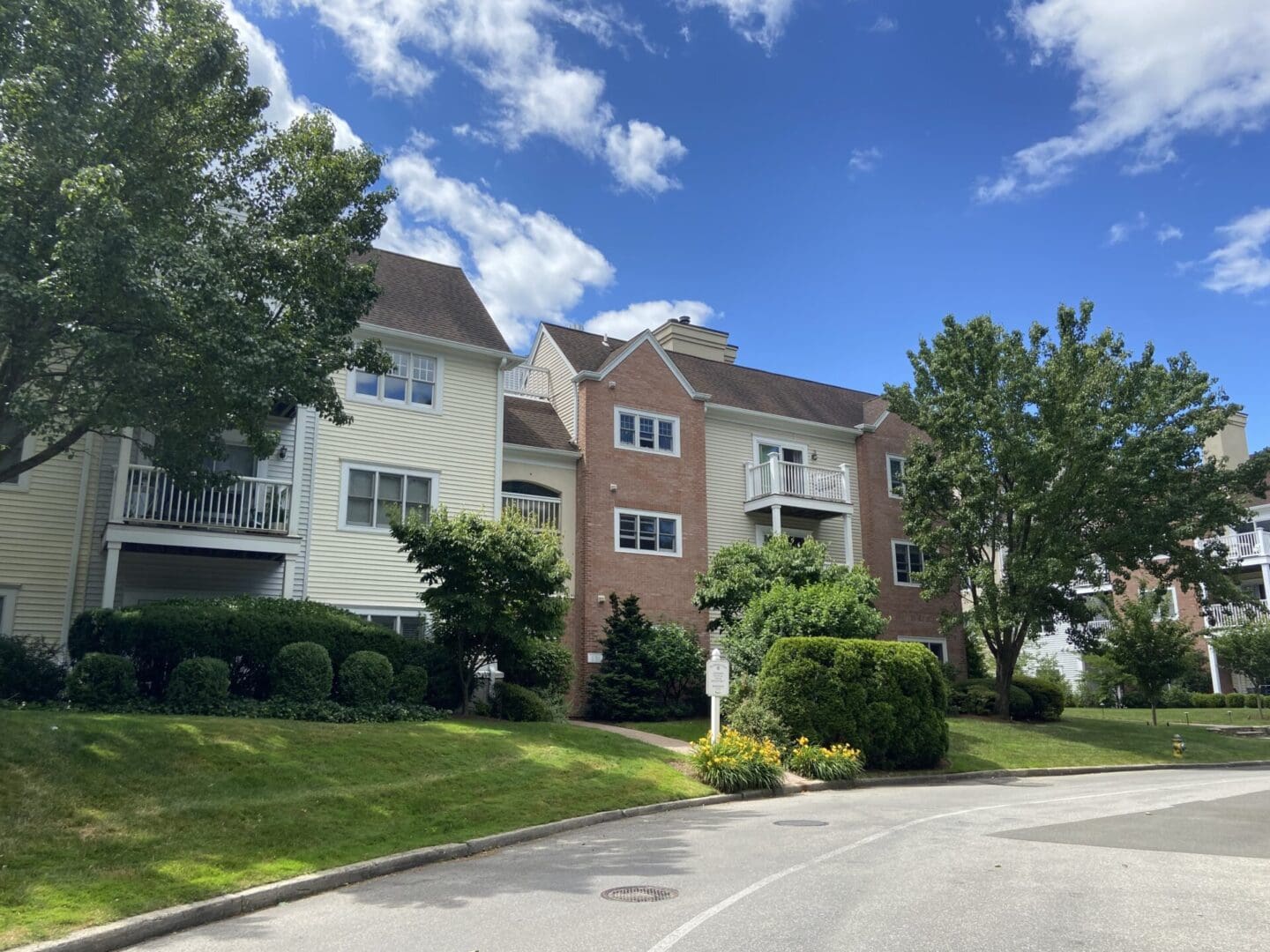 Multi-story apartment building with green lawn.