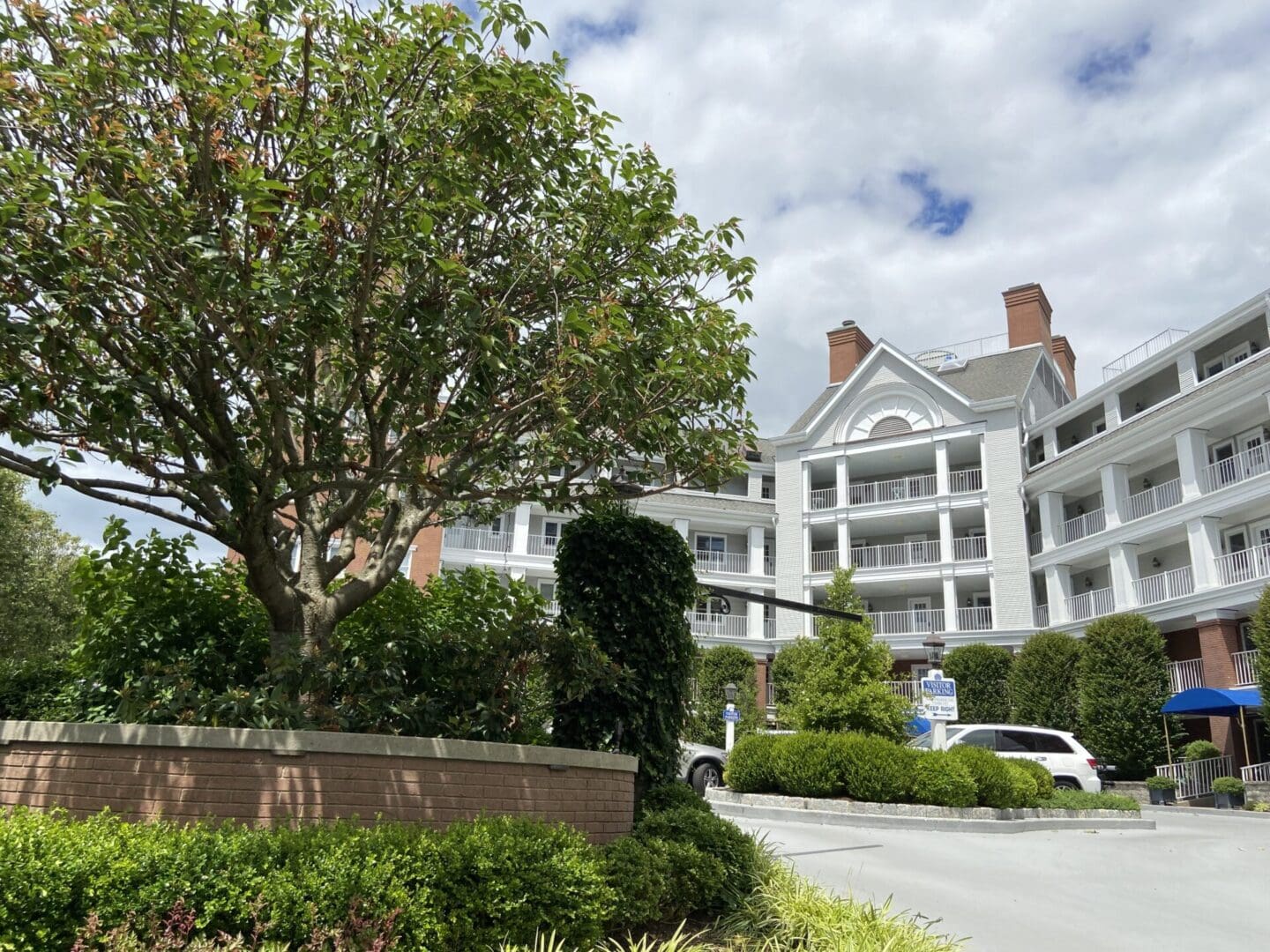 White building with trees and cars.