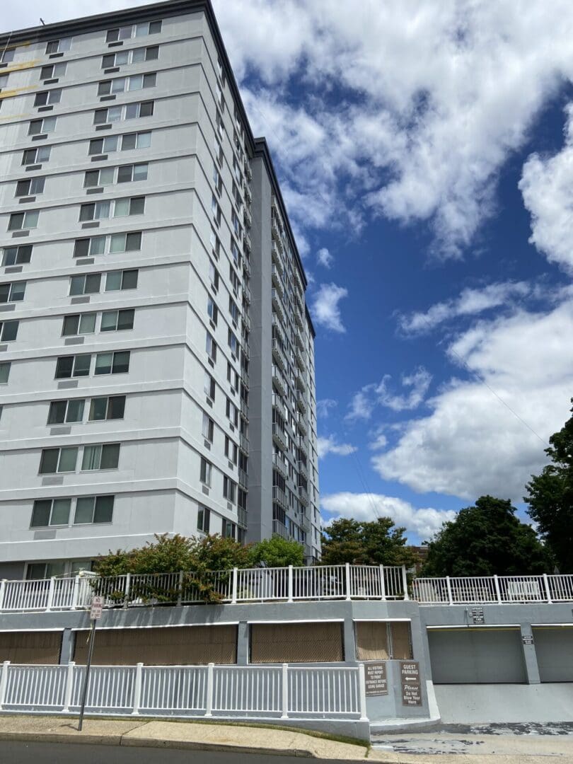 Tall apartment building with blue sky.