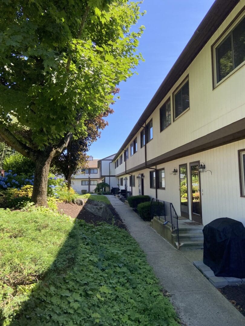 Walkway to a white apartment building.