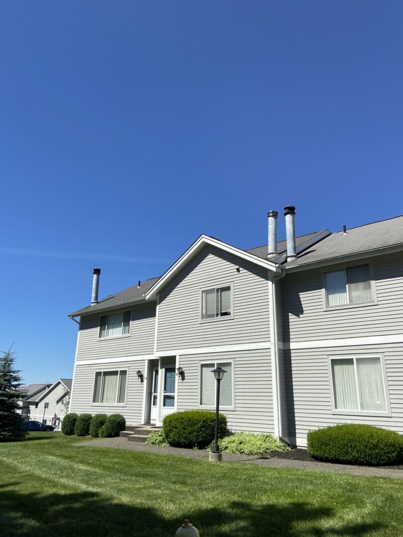 Gray siding house with green lawn.