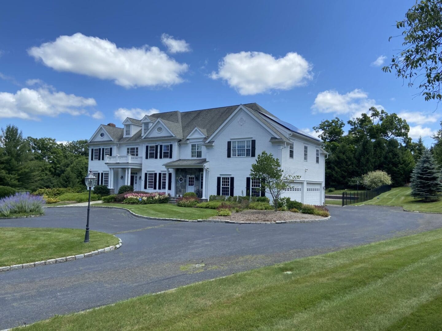 White house with driveway and green lawn.